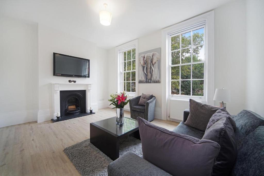 a living room with a couch and a fireplace at Large 2 Bed Apartment London Camberwell Champion Park Denmark Hill - Great For Long Stays in London