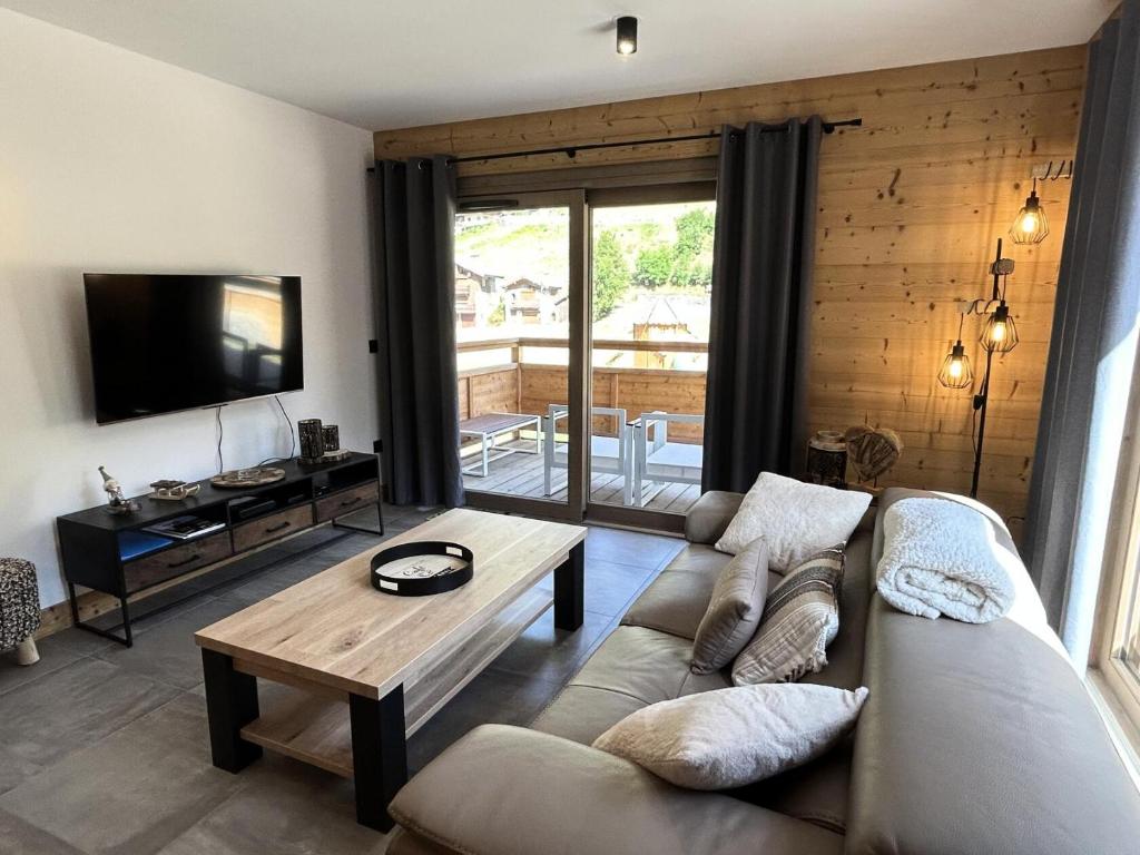 a living room with a couch and a table at Résidence LES TERRASSES DE LA VANOISE - Appartement LES TERRASSES DE LA VAN 924 in Champagny-en-Vanoise