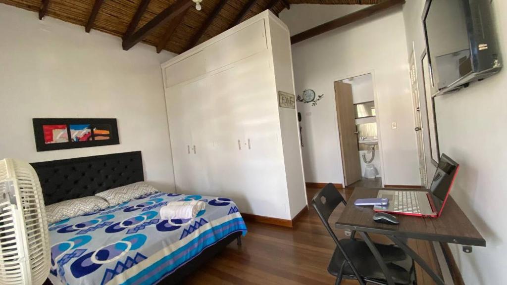 une chambre avec un lit et un bureau avec un ordinateur portable dans l'établissement Apartaestudios tipo loft Prado Station, à Medellín
