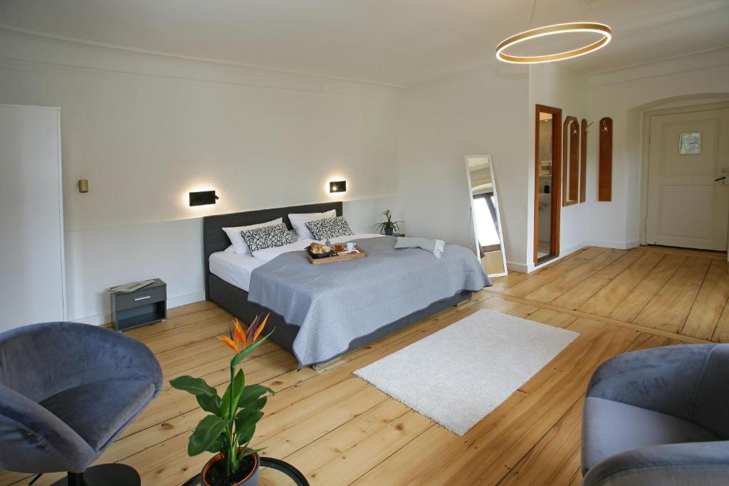 1 dormitorio con 1 cama y 2 sillas en Bed & Breakfast Müllers Klostermühle, en Münstertal
