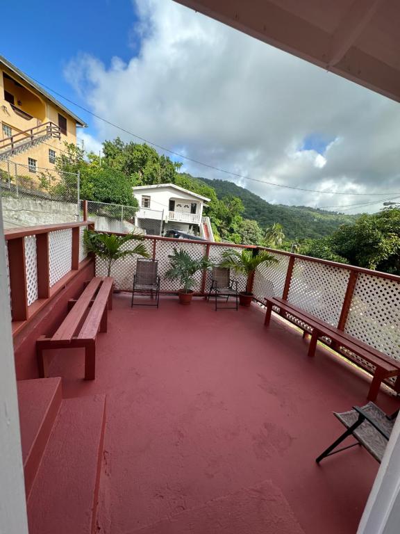 balcón con bancos y vistas a una casa en Homely environment ideal for a home away from home en Gros Islet