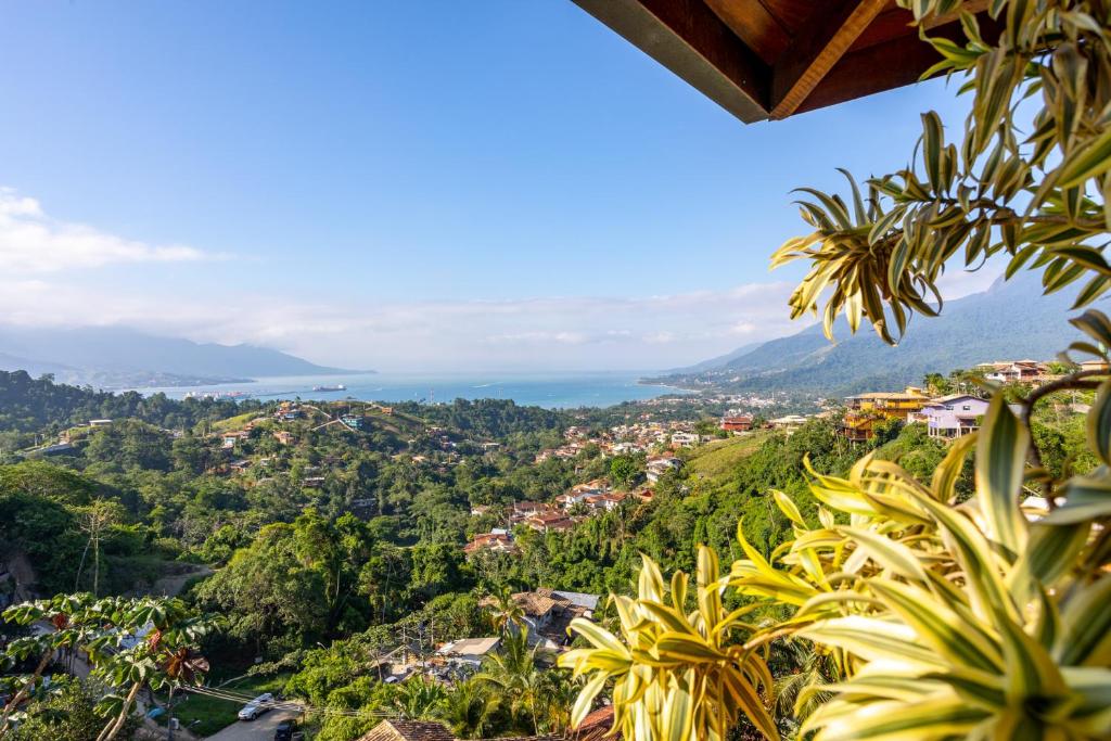 uitzicht op een stad vanaf een heuvel met bomen bij Casa Bambolê em Ilhabela in Ilhabela