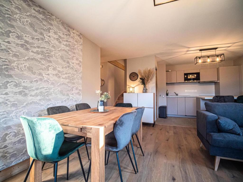 a dining room and kitchen with a wooden table and chairs at CHALET LUMI - Chalet CHALET MEIJE pour 6 Personnes 094 in Valmorel