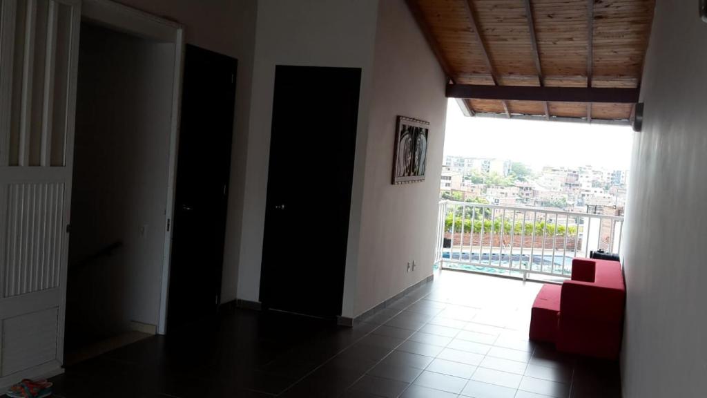 a living room with a red couch and a large window at Casa Provenza Bucaramanga in Bucaramanga