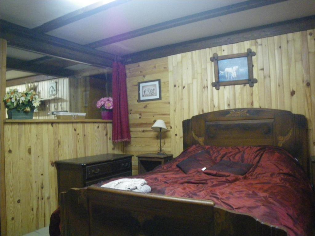 ein Schlafzimmer mit einem Bett und einem TV an der Wand in der Unterkunft Chambre quadruple du grand sapin 