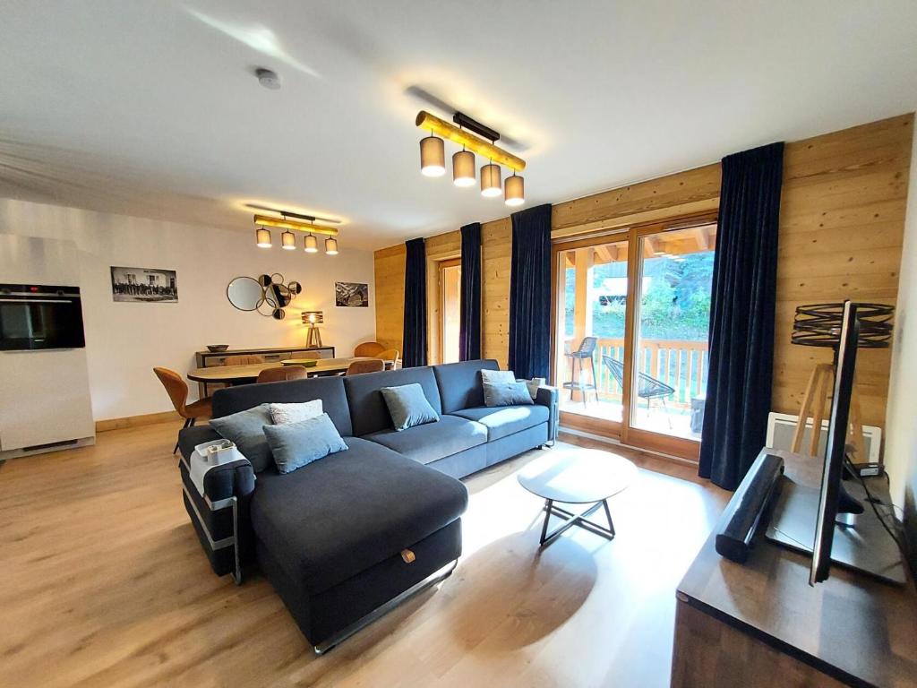 een woonkamer met een blauwe bank en een tafel bij Résidence LUMI BATIMENT B - Appartement LUMI B pour 4 Personnes 014 in Valmorel
