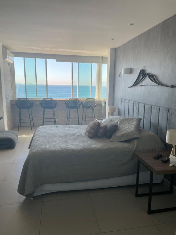 1 dormitorio con 1 cama y vistas al océano en Studio Avenida Atlântica, en Río de Janeiro