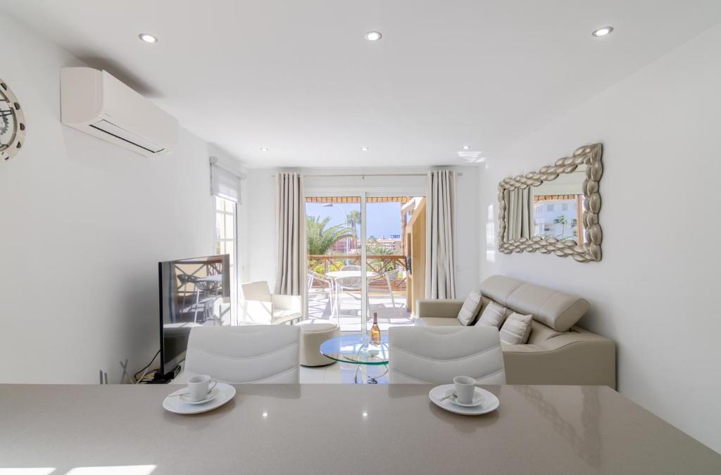 a white living room with white chairs and a couch at Mango La Caleta Hideaway in Adeje