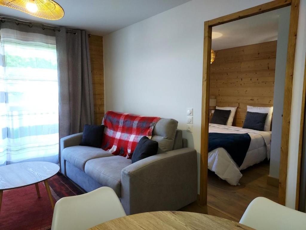 ein Wohnzimmer mit einem Sofa und einem Bett in der Unterkunft Résidence LUMI BATIMENT B - Appartement LUMI B pour 4 Personnes 754 in Valmorel