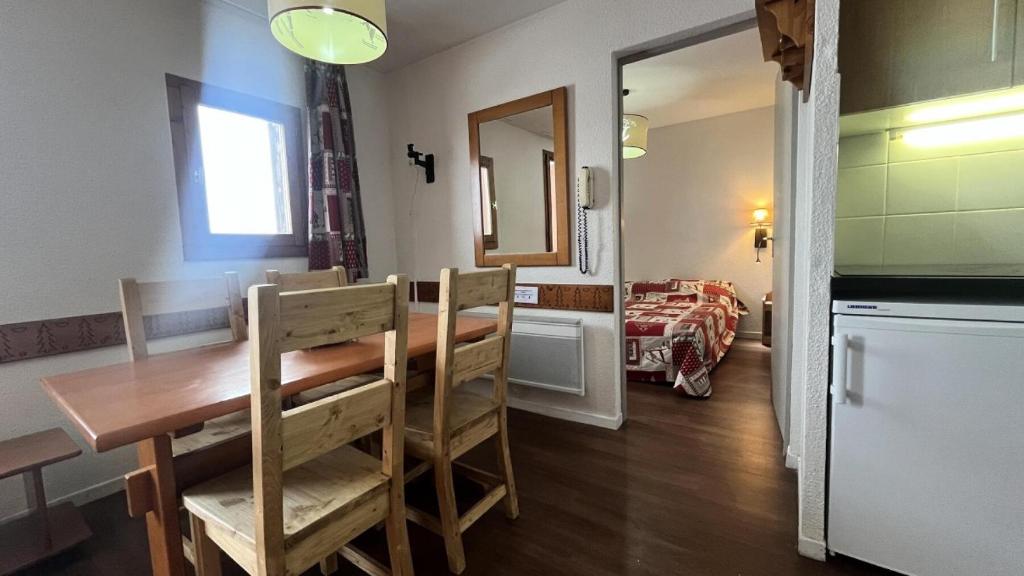 La Plagne Tarentaise的住宿－LE CERVIN - Appartement CERVIN 181，一间带木桌和椅子的用餐室