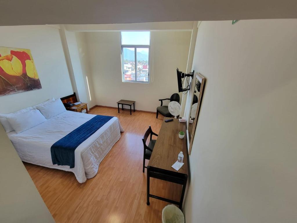 1 dormitorio con 1 cama y escritorio con mesa en HOTEL TRUEBA en Orizaba