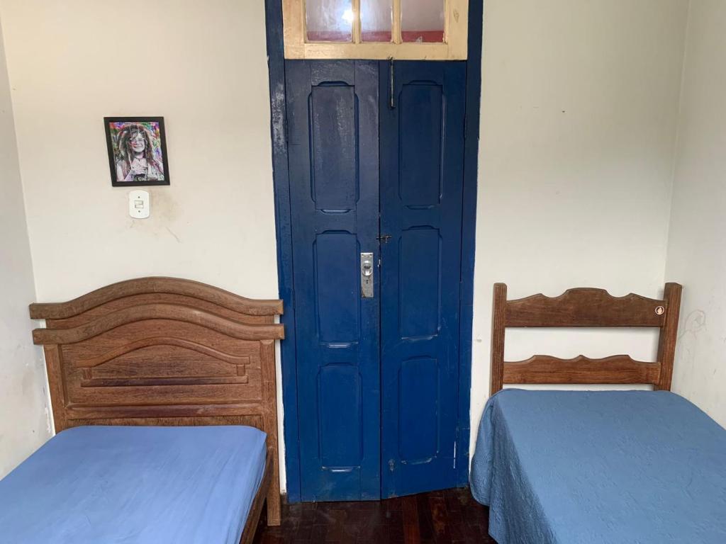 um quarto com duas camas e uma porta azul em República Cruz Vermelha em Ouro Preto