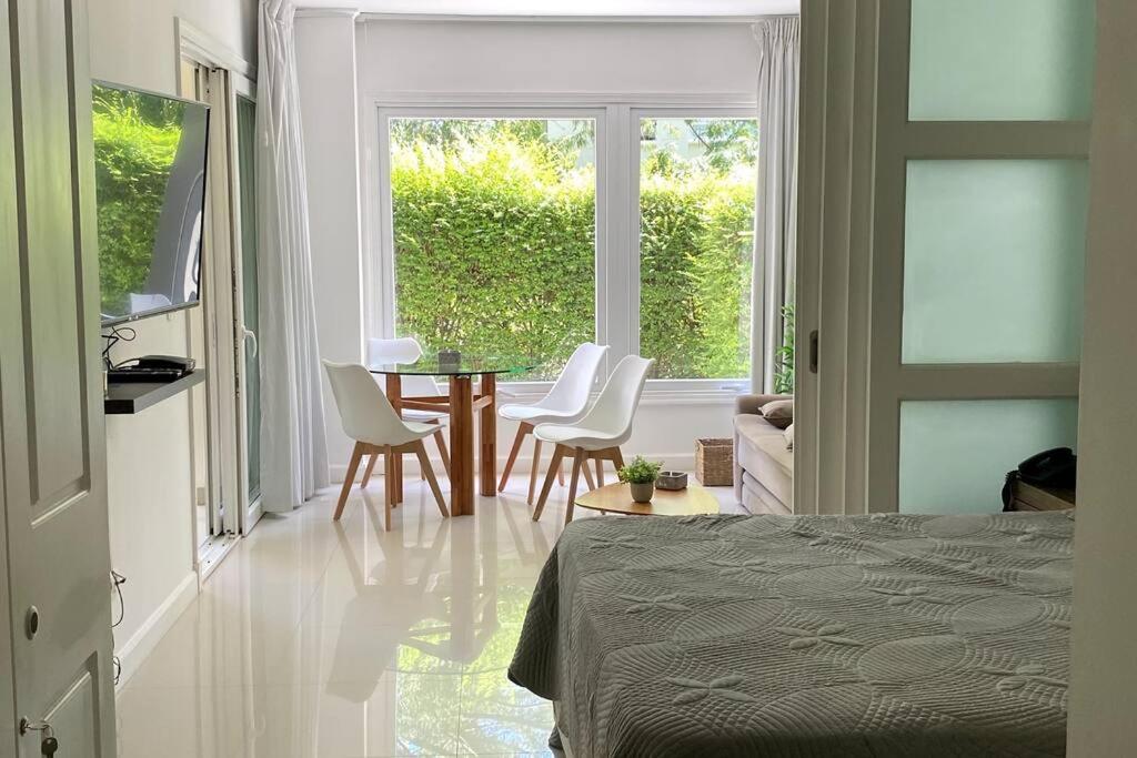 a bedroom with a table and chairs and a window at Depto PB con Jardín - Green Park in Punta del Este