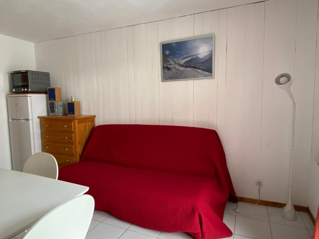 een rode bank in een kamer met een koelkast bij Appartement Valloire, 2 pièces, 4 personnes - FR-1-263-422 in Valloire