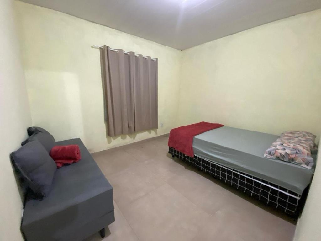una camera da letto con un letto e un divano di loft 2 sitio do barrigudinho a Saquarema