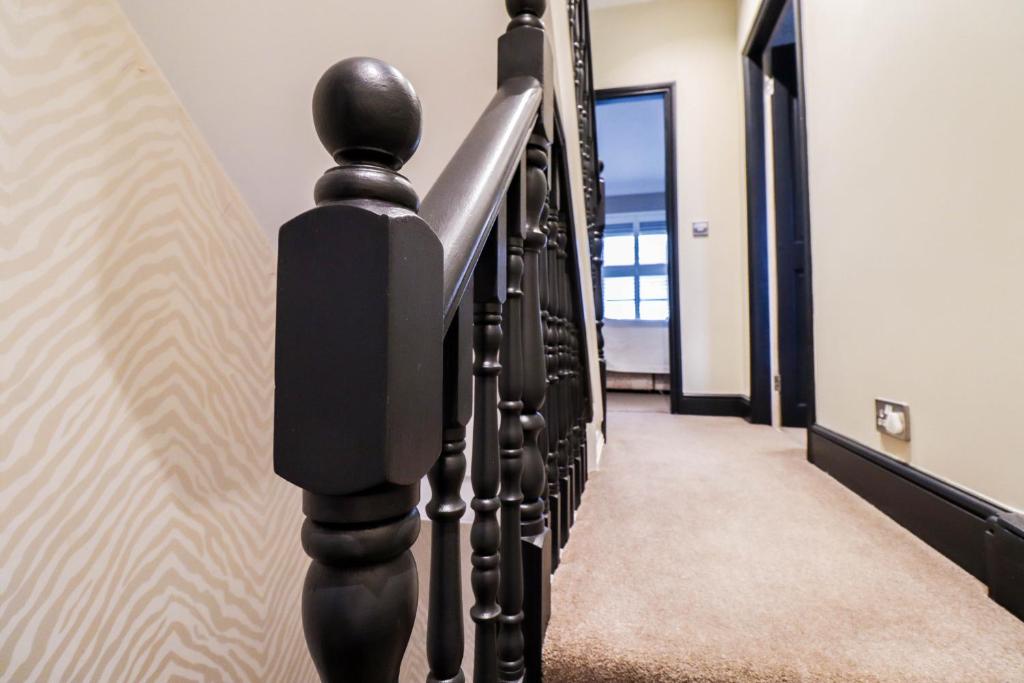 a hallway with black railings in a house at Chic 3-Bedroom Family Retreat in Stratford, Fast internet and near shops in London