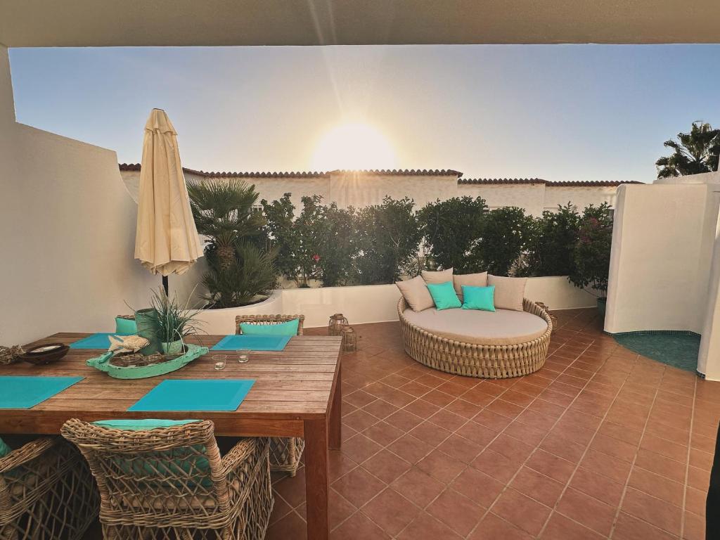 a patio with a table and a couch and umbrella at Casa BLANKA Bahia Playa Anlage Costa Calma in Costa Calma