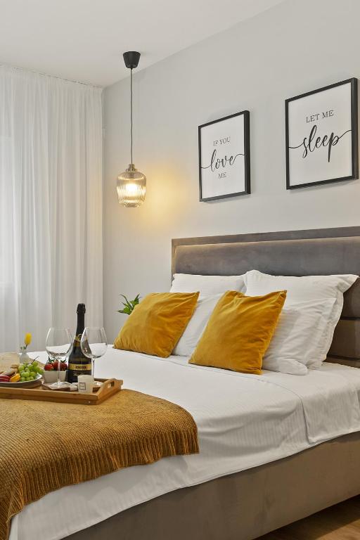 a bedroom with a bed with white and yellow pillows at Mido Park Apartment with Private Parking & Self Check-in in Bucharest