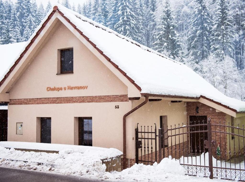 a building covered in snow with trees in the background at Chalupa u Havranov in Bystrá