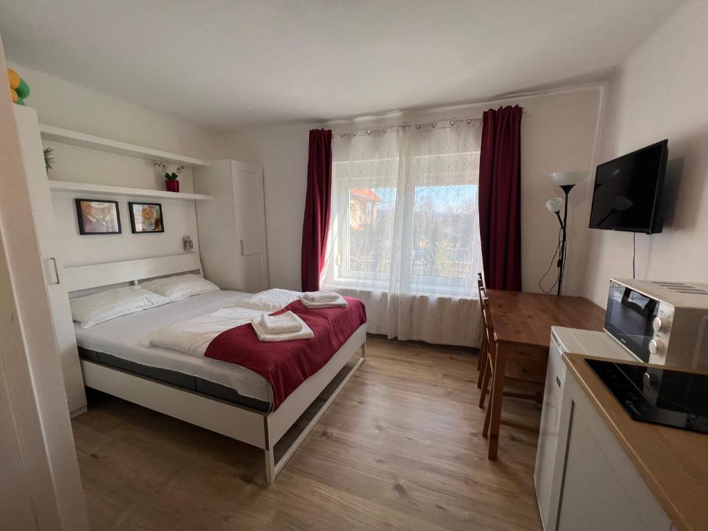 a bedroom with a bed and a desk and a microwave at Villa Angel'OK in Hévíz