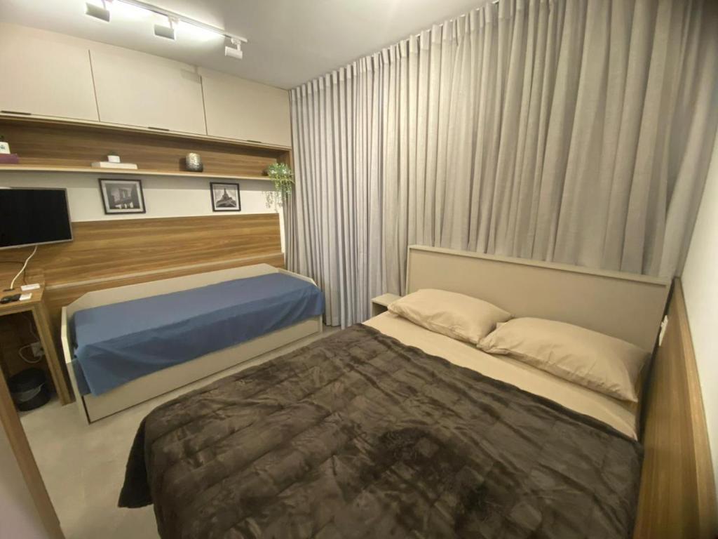 sypialnia z łóżkiem i telewizorem w obiekcie Studio 2 Patteo Helbor - MAIA w mieście Guarulhos