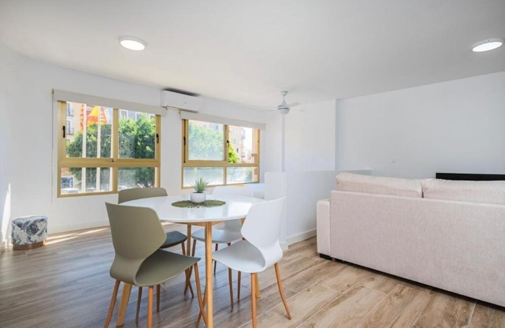 a living room with a table and chairs and a couch at Vive la Vila cozy apartment by the beach in Villajoyosa