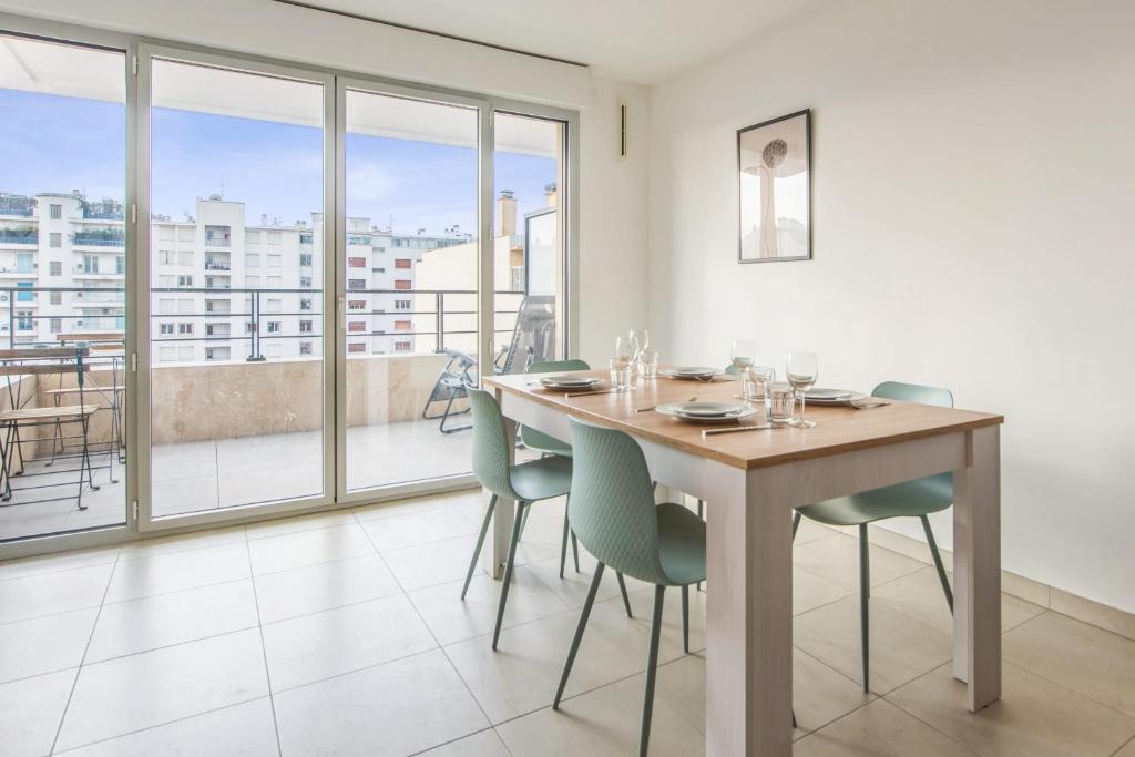 une salle à manger avec une table et des chaises et un balcon dans l'établissement Appartement Juanesco - Welkeys, à Juan-les-Pins