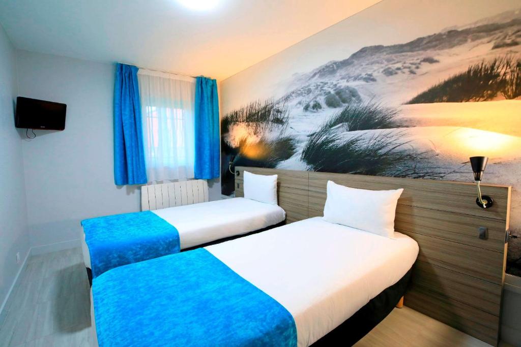Postel nebo postele na pokoji v ubytování Brit Hotel Le Polder