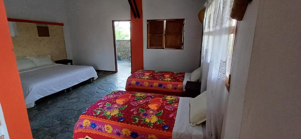 a room with two beds and a bed sidx sidx sidx sidx at finca hotel palmas frente a panaca in Quimbaya