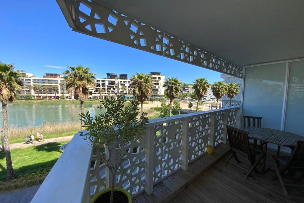 einen Balkon mit einem Tisch und Blick auf das Wasser in der Unterkunft Le Sublime- Vue climatisation et parking ! in Montpellier