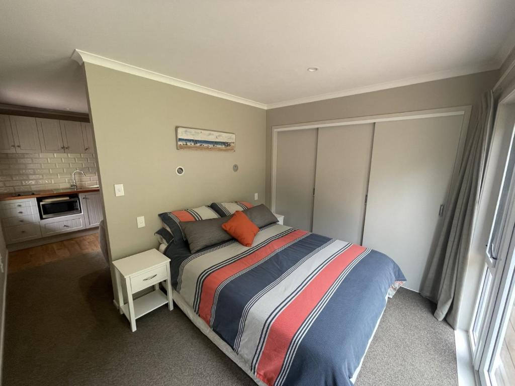 a bedroom with a bed with a striped blanket at Guest Wing in Richmond Downs in Walton