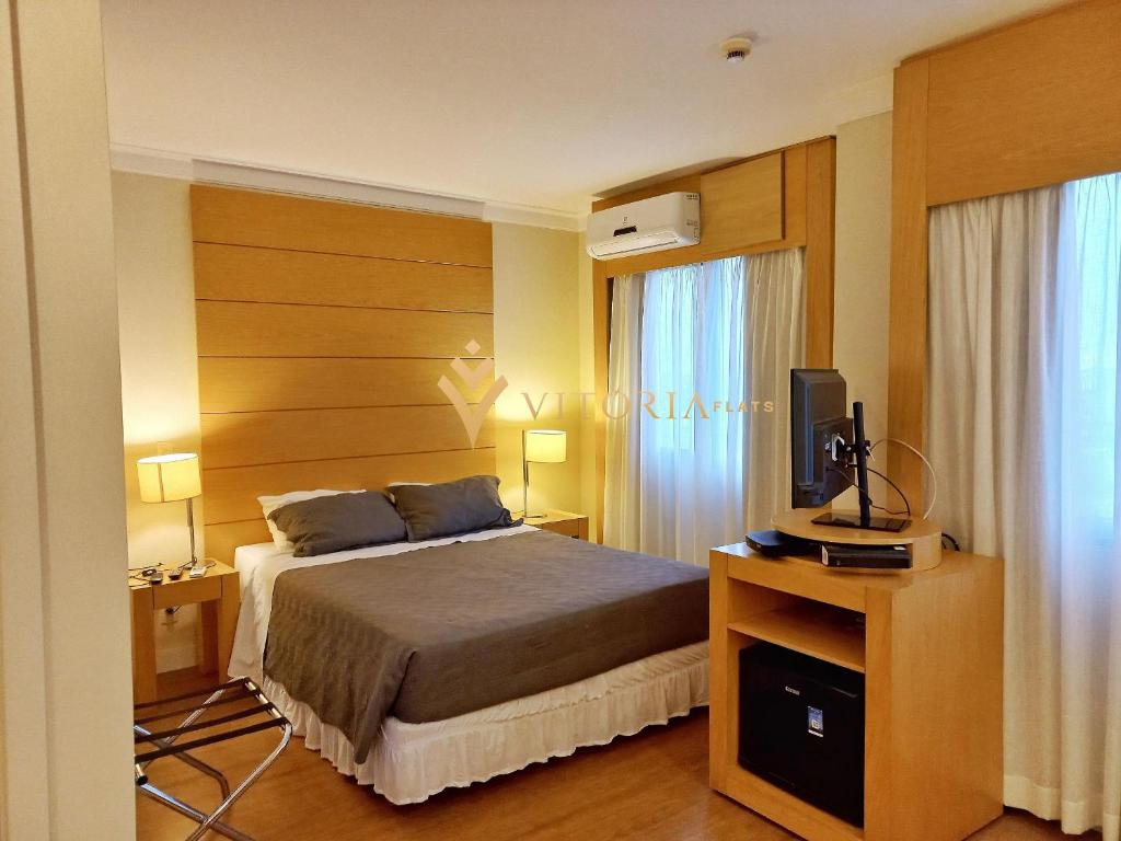 サンパウロにあるELEGANCE SUÍTES CONGONHASのベッドとテレビが備わるホテルルームです。