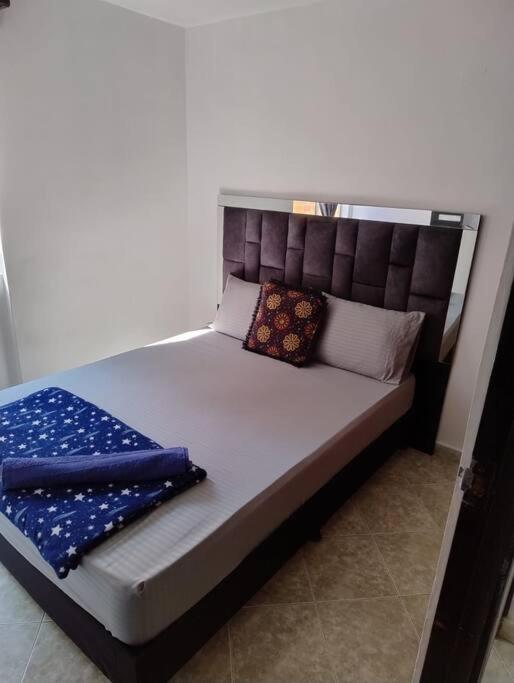 ein Bett mit zwei Kissen auf einem Zimmer in der Unterkunft comodidad y ubicación. in Medellín