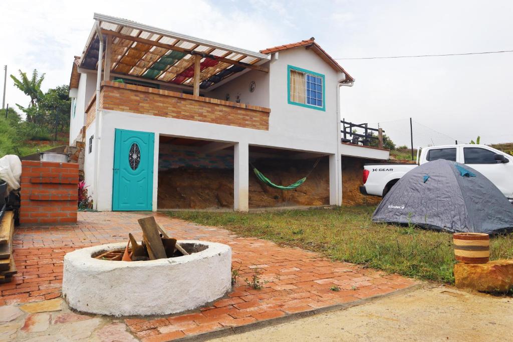 mały dom z niebieskimi drzwiami na ceglanym dziedzińcu w obiekcie Villa Bonita w mieście Bucaramanga