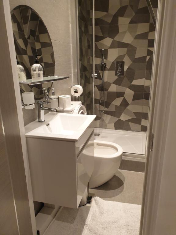 a bathroom with a sink and a toilet and a shower at Central London property-ensuite, double and budget room in London