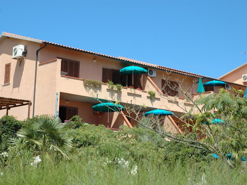 een gebouw met blauwe parasols ervoor bij Rio D'Elba in Rio nell Elba