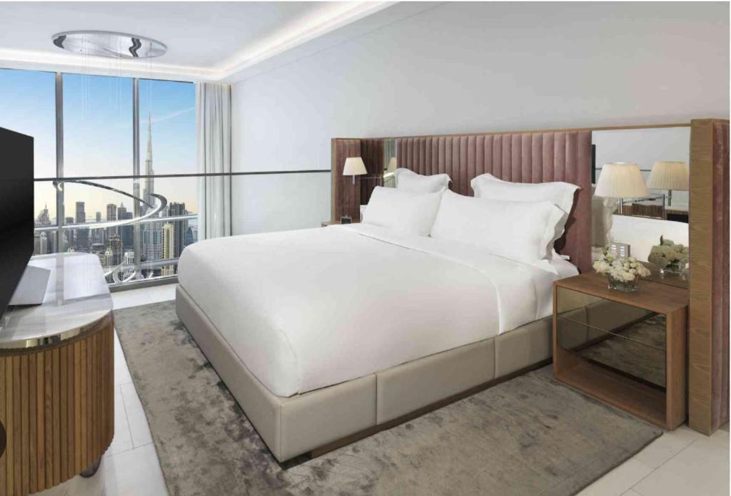 a bedroom with a large white bed and a large window at Down Town Dubai, 2 min for Dubai Mall in Dubai