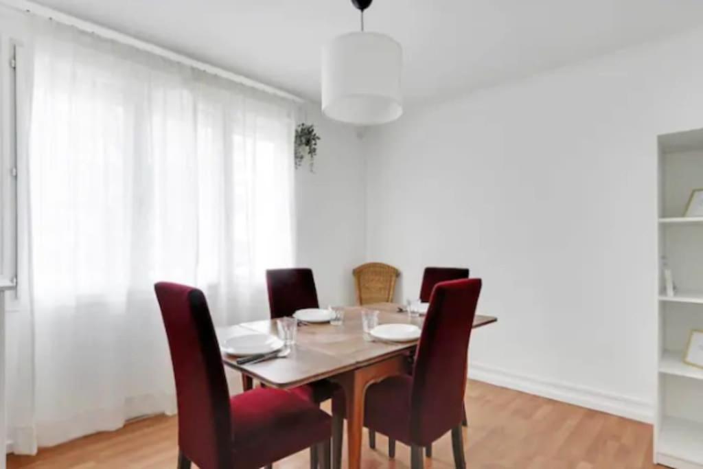 a dining room with a table and chairs at Superbe appartement lumineux et calme in Saint-Ouen