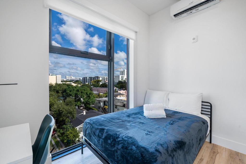 een slaapkamer met een bed en een groot raam bij Pastel Apartments in Miami