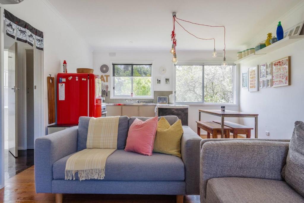 uma sala de estar com um sofá e uma cozinha em Shoreline Sanctuary - A Retro Family Beach Shack em Somers