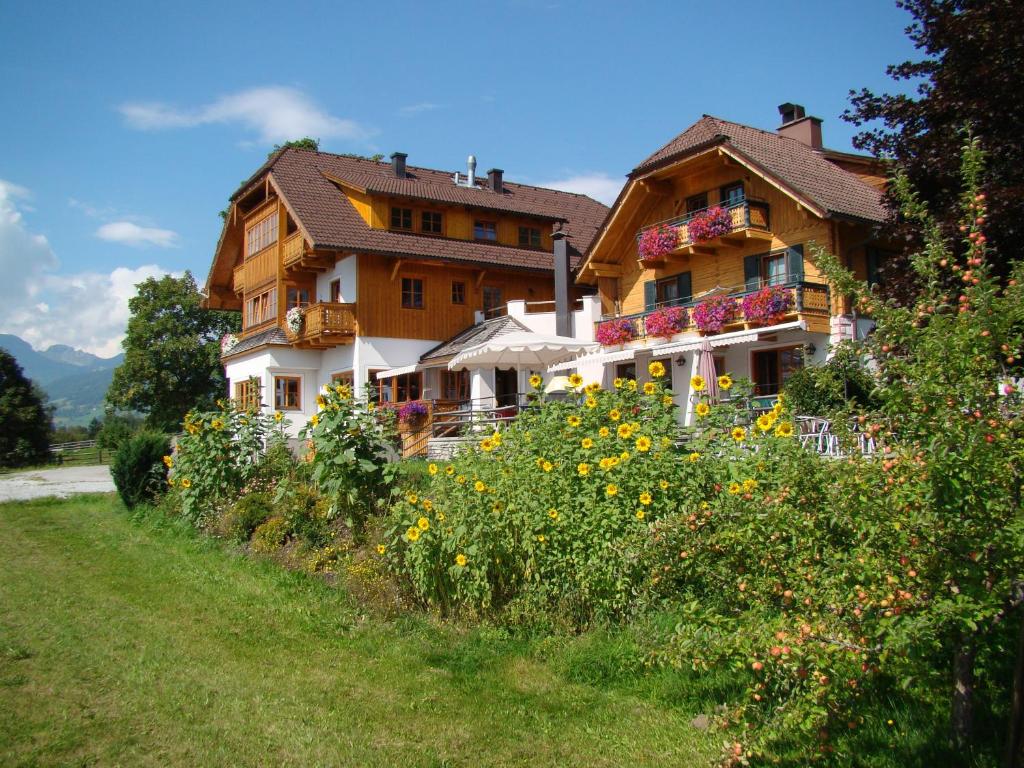 ein Haus auf einem Hügel mit einem Blumenfeld in der Unterkunft Panoramahaus Steiner in Mariapfarr