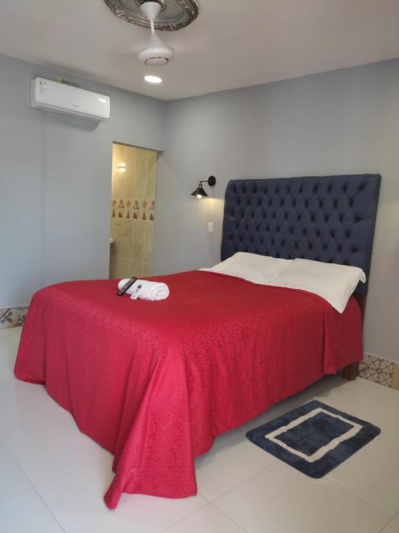 a bedroom with a red bed with a red blanket at HOSTAL RIVAS INNS in Rivas