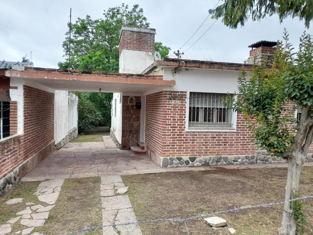 an old brick house with an open doorway at Alquiler de Casa en Cosquin temporario in Cosquín