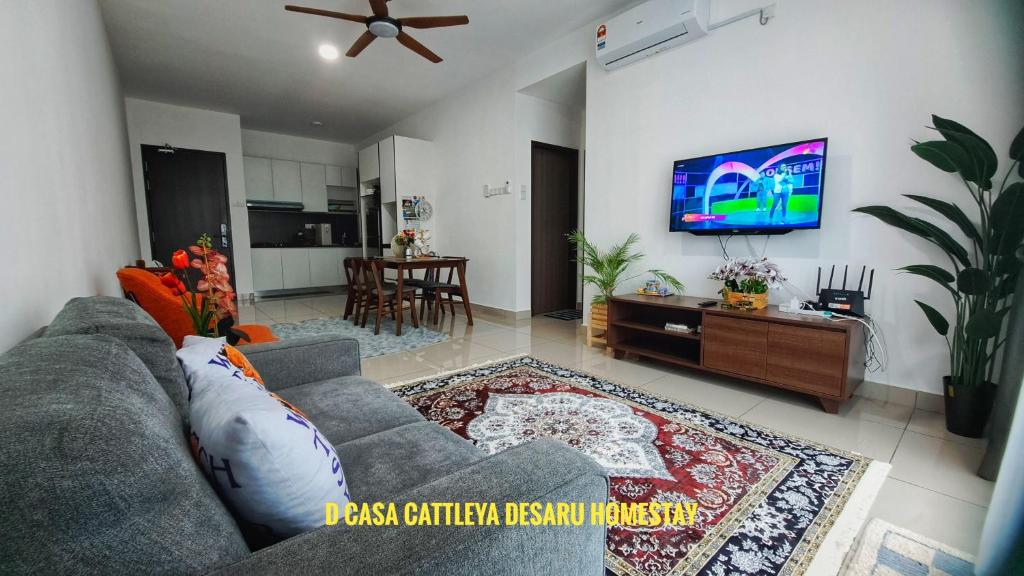 sala de estar con sofá y TV de pantalla plana en D Casa Cattleya Desaru en Kota Tinggi