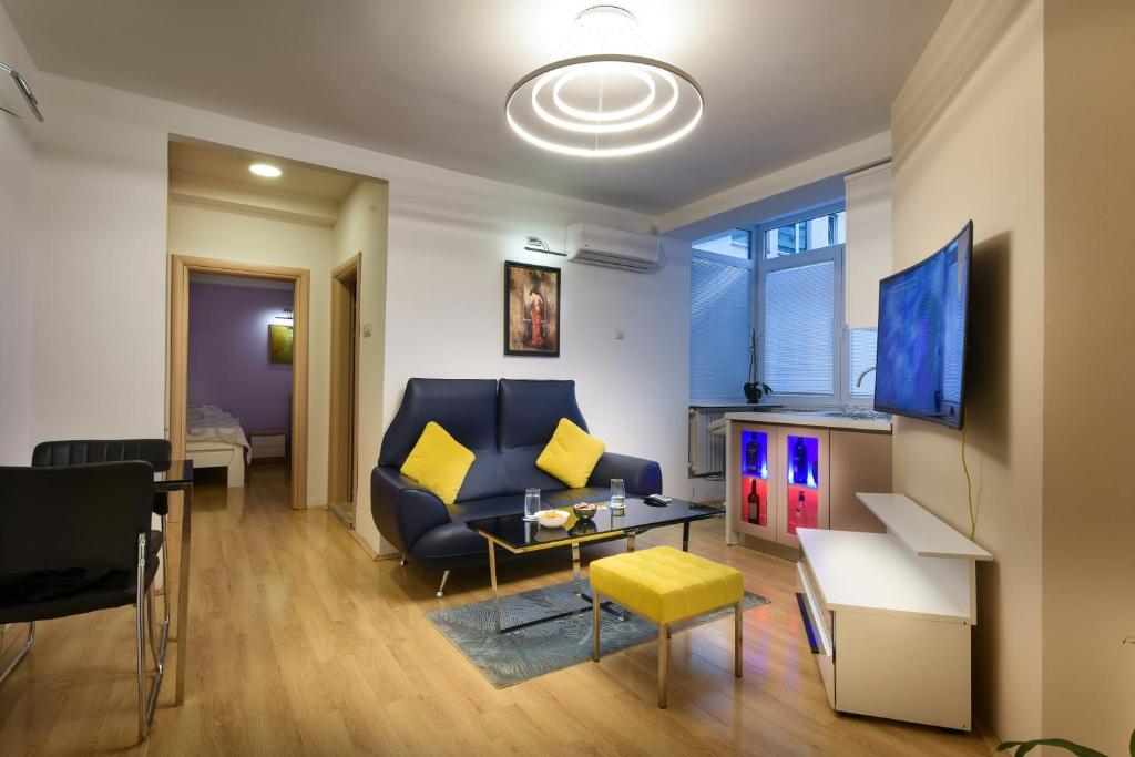 sala de estar con sofá azul y almohadas amarillas en Skopje Luxury Apartments en Skopje