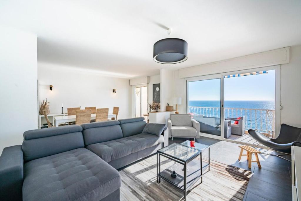 - un salon avec un canapé bleu et une vue sur l'océan dans l'établissement Wonderful 2 bedroom apartment with sea view, à Cannes