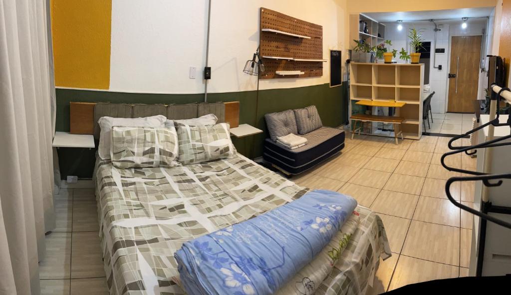 1 dormitorio con 1 cama y 1 silla en Loft Sé -Centro São Paulo, en São Paulo