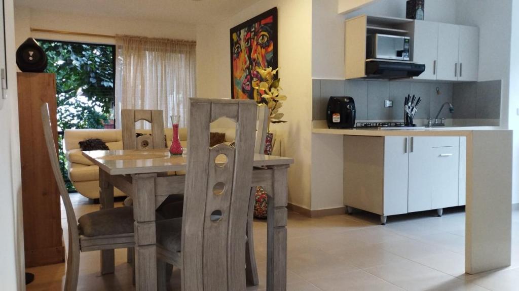 a kitchen and dining room with a table and a dining room at Apartamento Laura María in Medellín