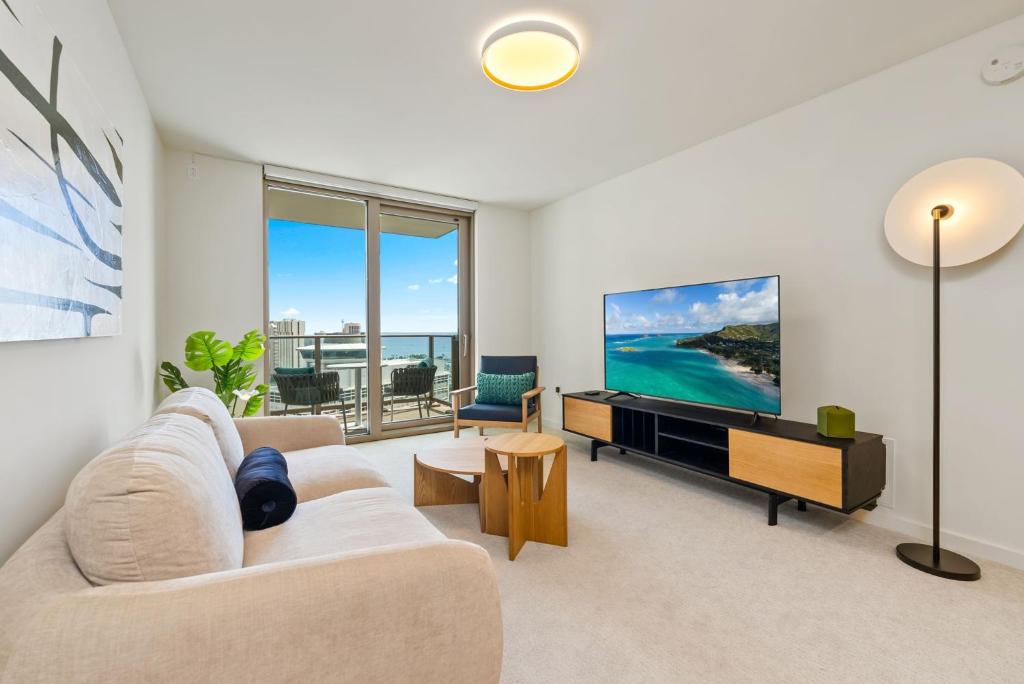 een woonkamer met een bank en een tv bij Sky Ala Moana 3305 condo in Honolulu
