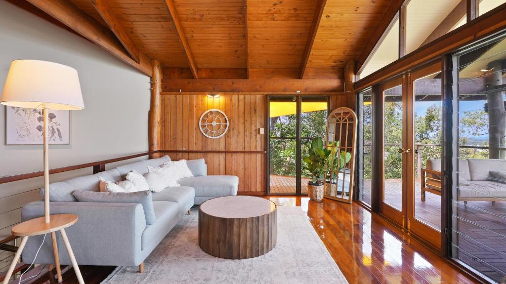 a living room with a couch and a table at Rainforest Treehouse Sanctuary - with ocean views in Smithfield